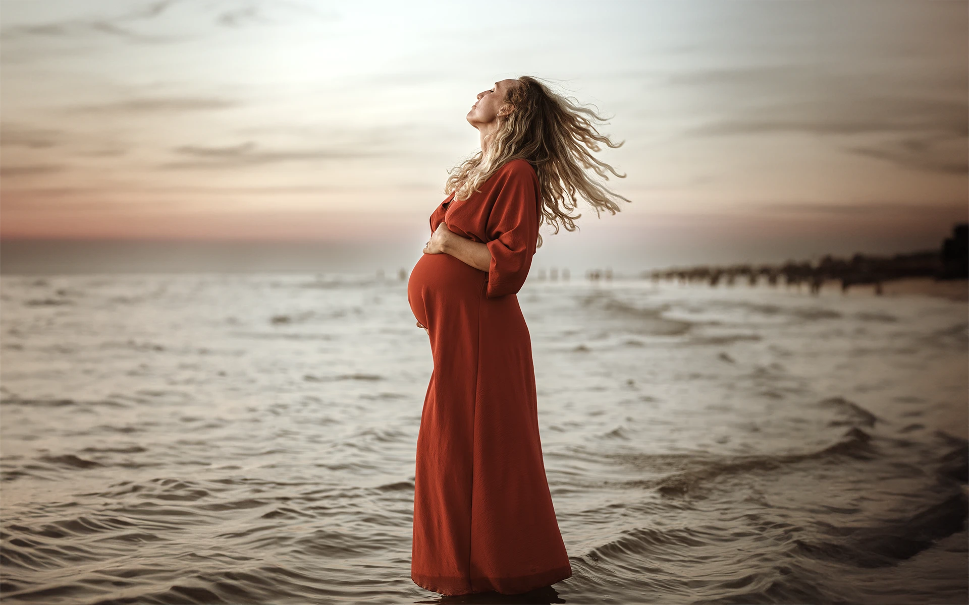 Zwangere vrouw aan zee tijdens een Zwangerschapsshoot