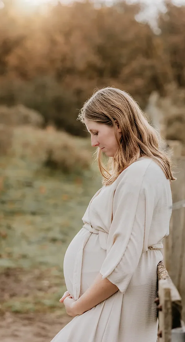 Zwangerschapsshoot Noord Holland duinen vrouw tegen hek