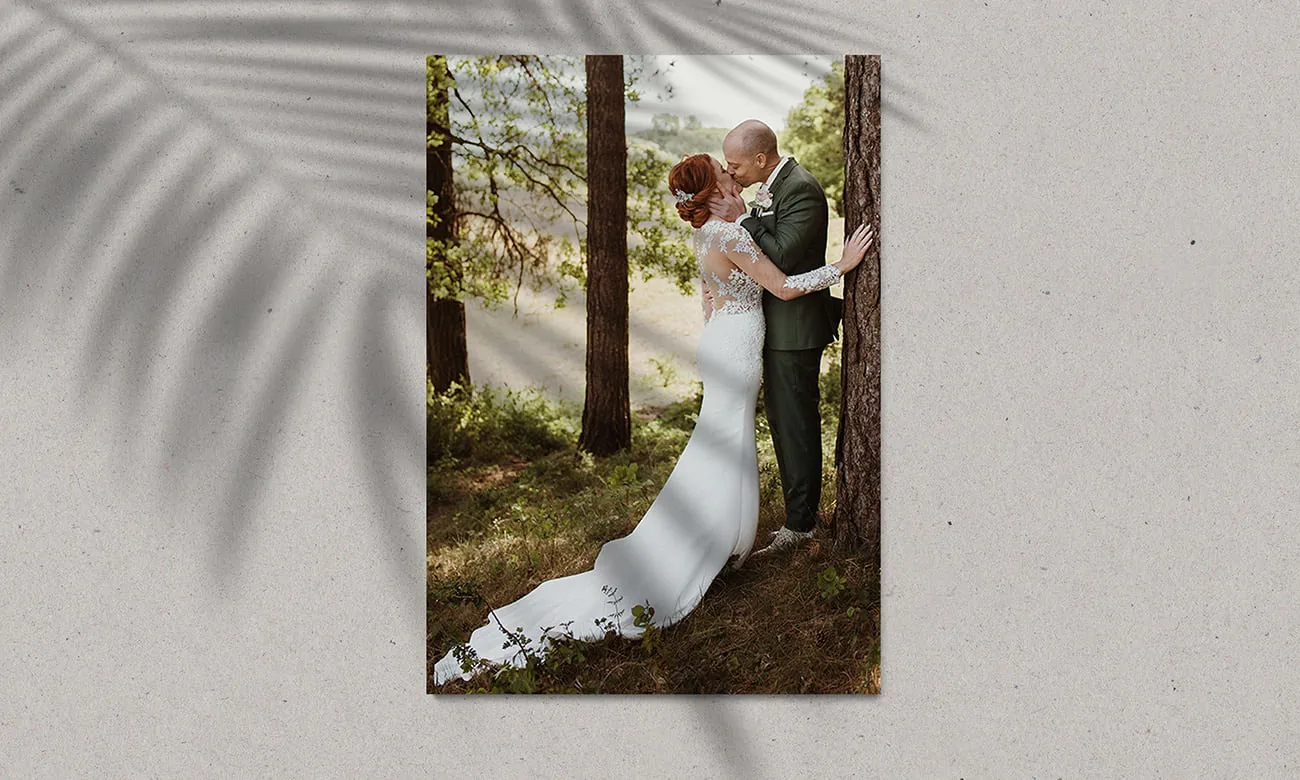 Voorbeeld van Foto’s te laten afdrukken. Een getrouwd stel die elkaar kussen tussen de bomen.