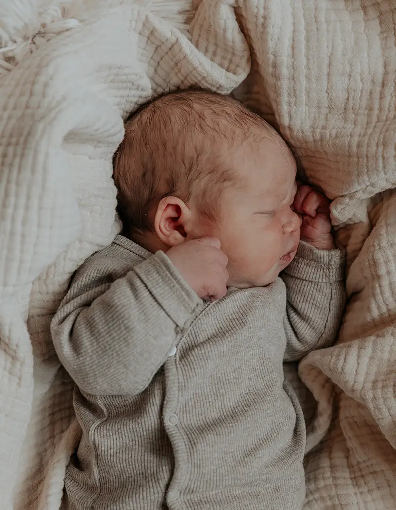 slapende baby in reiswieg newbornshoot in noord holland